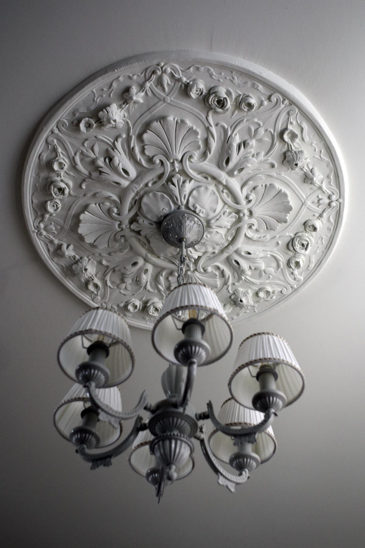 Large oval ceiling rosette with chandelier centred beneath it