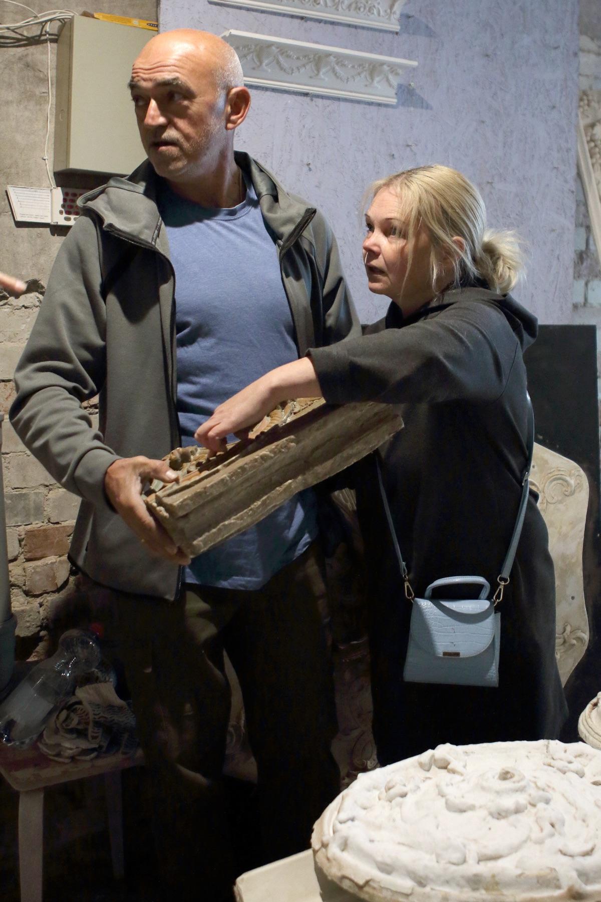 Restorers examining a fragment of antique cornice in the studio