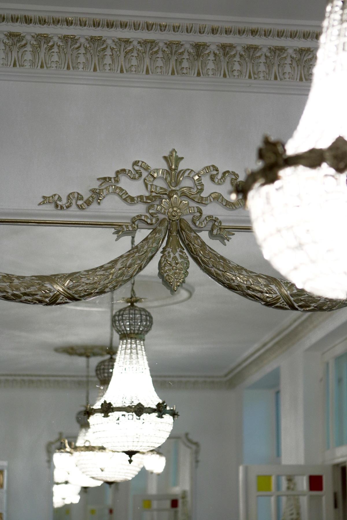 Sunlit enfilade with plaster frieze, ceiling drapery and crystal chandeliers