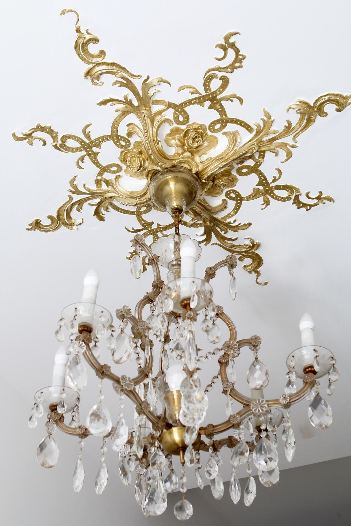 Star-shaped gilded ceiling rosette with roses and crystal chandelier